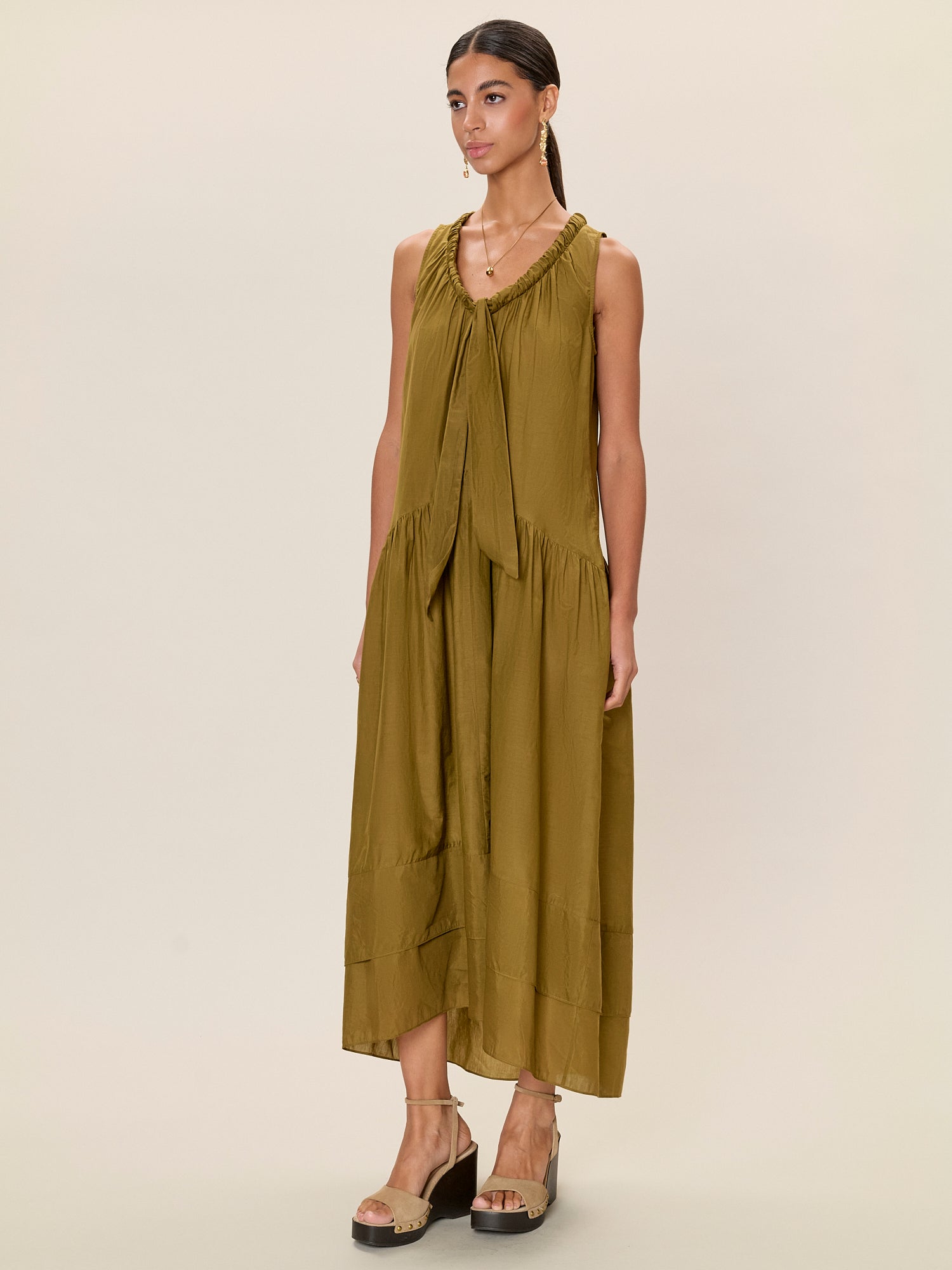 Woman wearing a green dress against a beige background