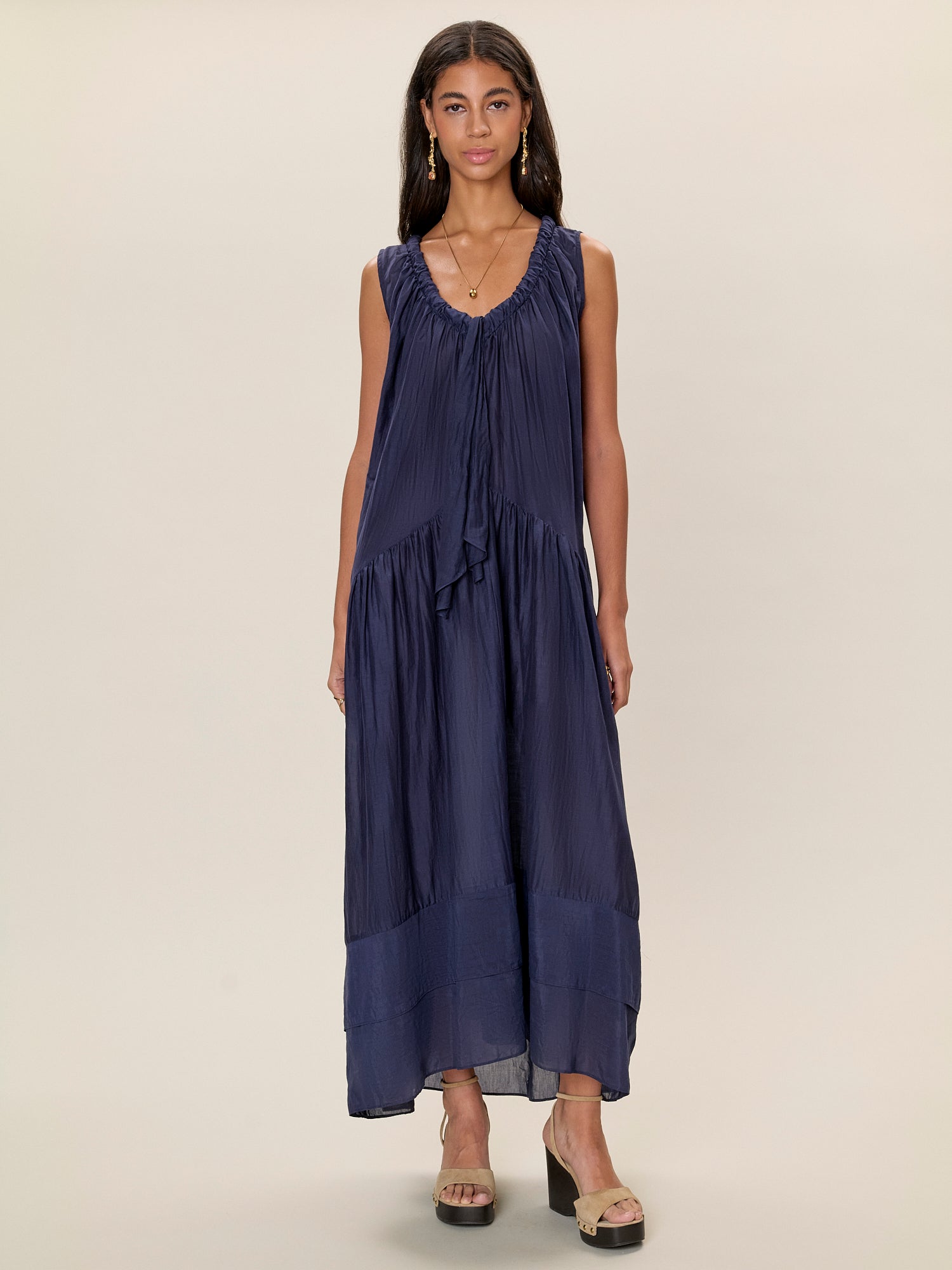 Woman wearing a navy blue dress on a beige background