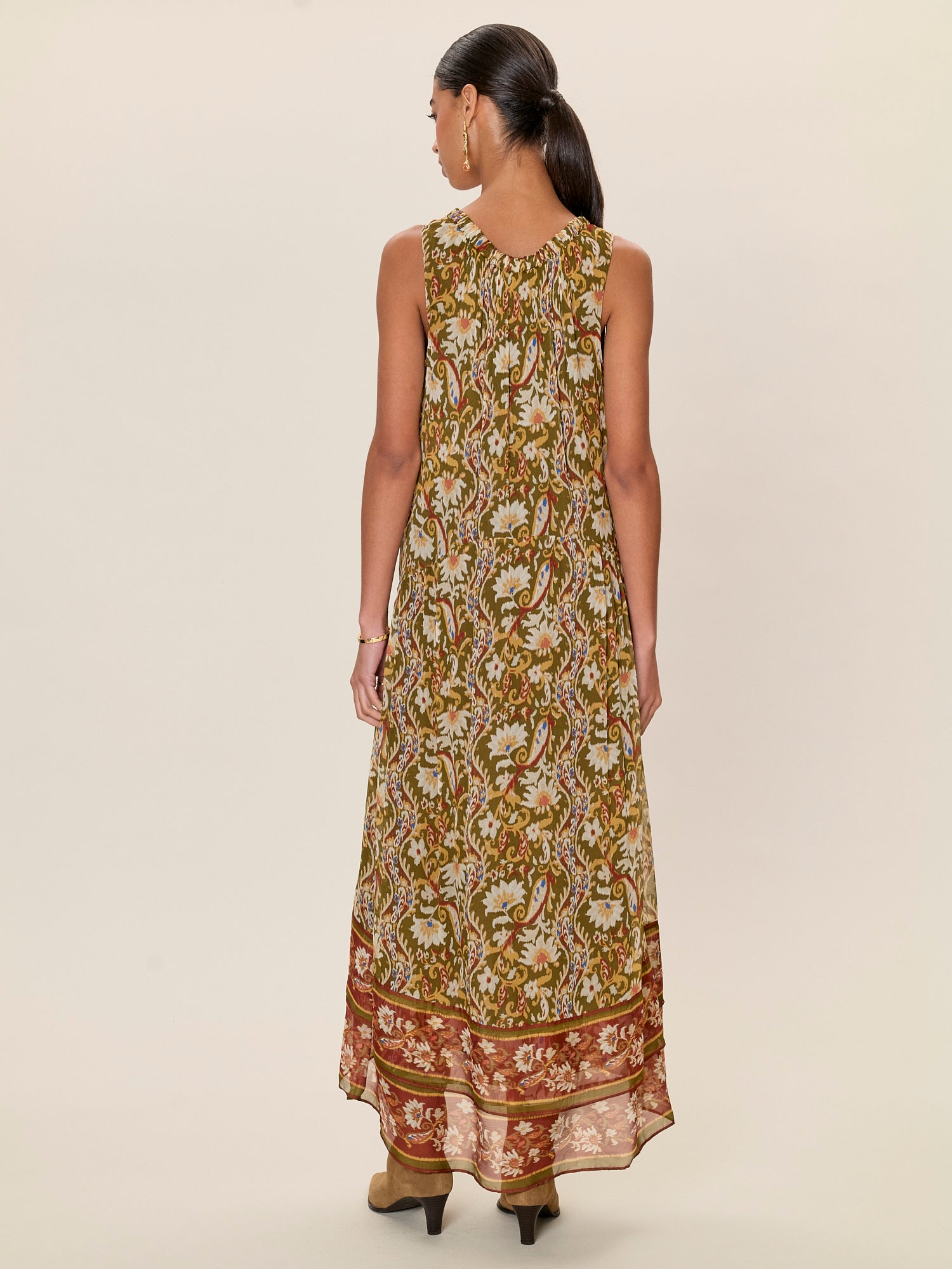 Woman wearing a long floral dress on a beige background