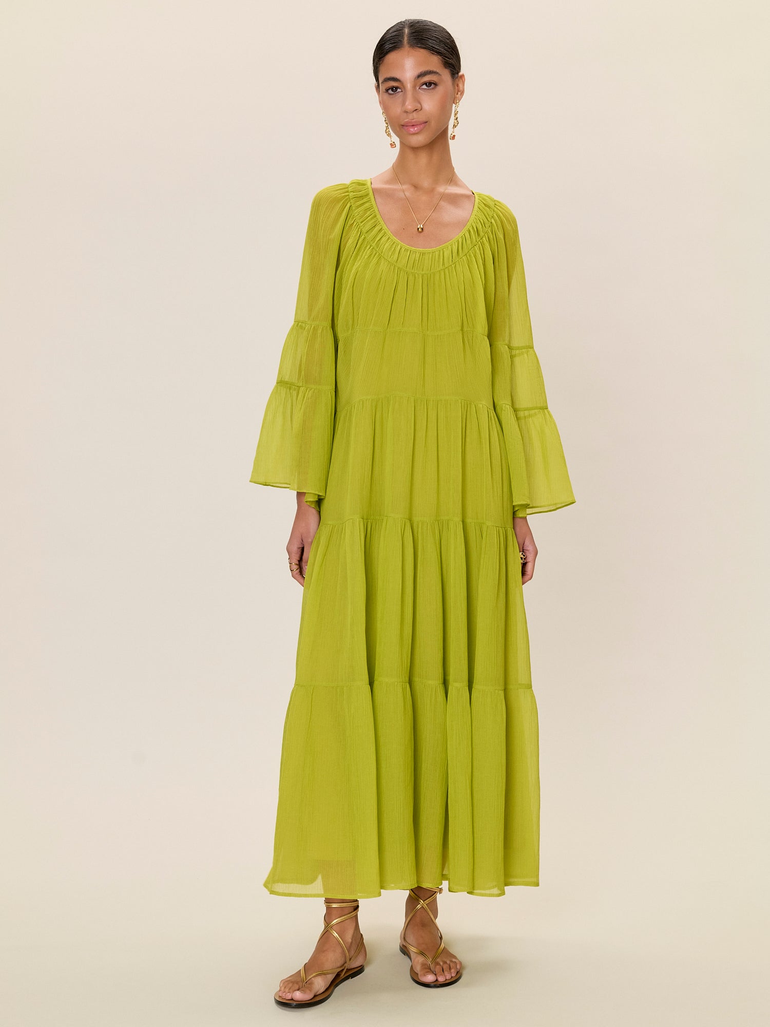 Woman wearing a green dress against a beige background